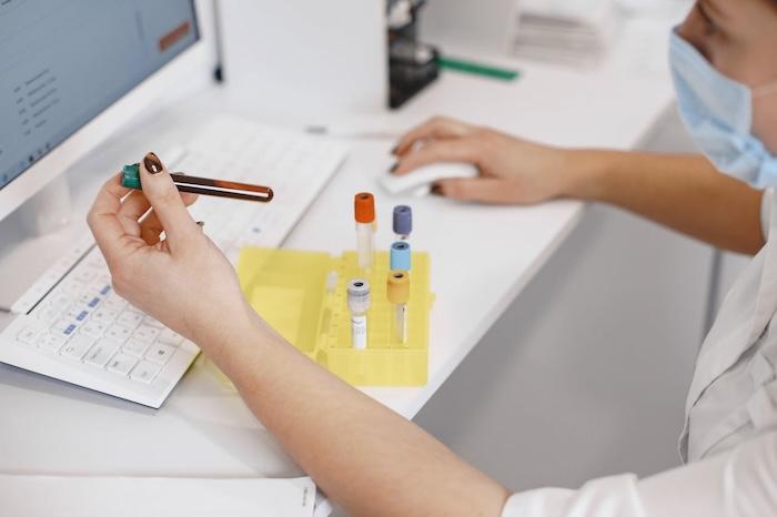 A clinician reviewing lab samples at a workstation